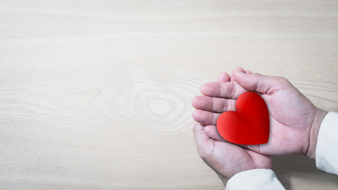 Person's Hands Holding a Red Heart Flatlay